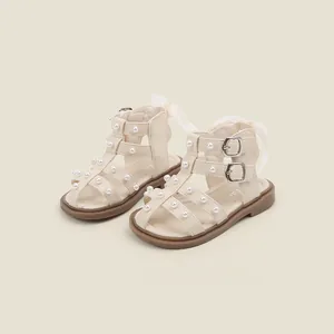 Detailed view of beige toddler girl sandals with elegant pearl decorations and soft soles.