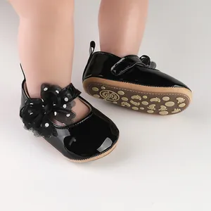 Detail van zwarte lakschoentjes voor baby's met polkadot strik en zool met profiel.