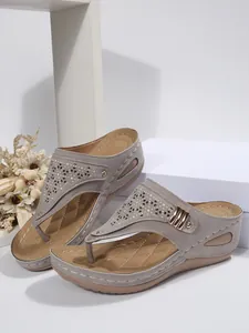 Side view of stylish grey wedge thong sandals with laser-cut patterns and metal buckle