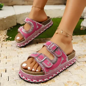 Close-up of pink platform sandals with sparkling rhinestones and double buckles.