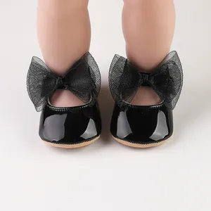 Primer plano de zapatos de princesa para bebé en charol negro con grandes lazos de malla