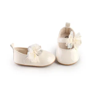 Detailweergave van de gebroken witte baby prinsessenschoenen met een kanten bloem