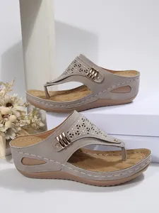 Side view of grey women's wedge sandals with laser-cut patterns and metal buckle