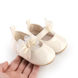 Gedetailleerd beeld van crèmekleurige babyschoentjes met mesh strik ter vergelijking van maat