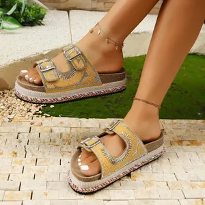 Close-up of yellow platform sandals with pearl beads and rhinestone buckles.