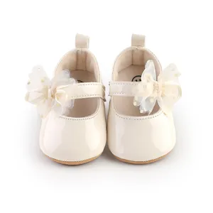 Gedetailleerde weergave van elegante crème baby prinsessenschoentjes met mesh strik
