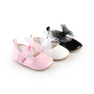 Detalle de zapatos para bebé niña con lazos de malla en rosa, blanco y negro