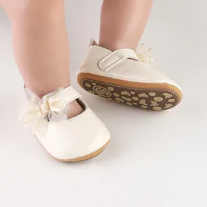Detailweergave van crème lakschoenen voor baby's met gaasstrik en antislipzool