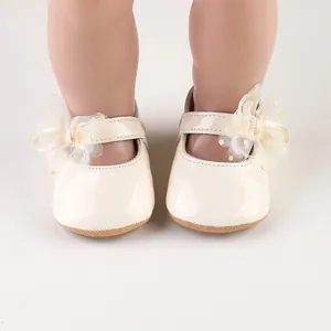 Detail van baby prinsessenschoenen met glanzende afwerking en tule strik detail.