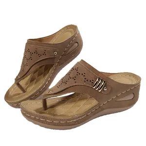 Stylish brown wedge thong sandals for women featuring laser-cut patterns and gold rivets.