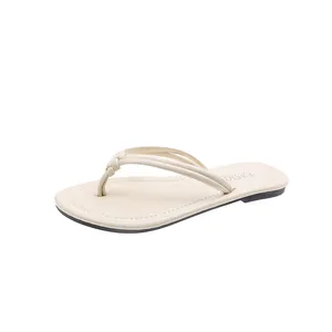 Elegant cream thong sandals with thin knot straps and decorative stitching