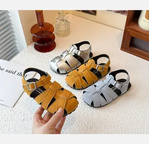 Detailed view of retro woven closed-toe children's sandals in yellow, silver and blue.