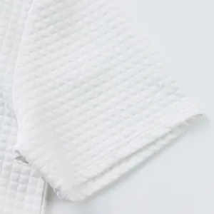 Nahaufnahme der weißen Jacquard-Struktur am Ärmel eines schweren Baumwoll-Poloshirts.