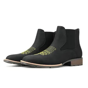 Detailaanzicht van zwarte Chelsea boots met geel borduurwerk en elastische zijpanelen