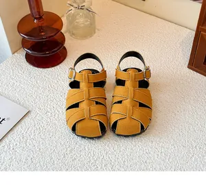 Detailed view of yellow children's woven Roman sandals with a closed-toe design and buckle straps