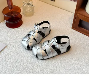 Close-up of silver woven children's retro Roman sandals with closed-toe and buckle straps.