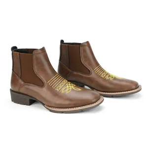 Gedetailleerd zijaanzicht van bruine Chelsea boots voor heren met geel borduursel.