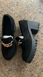 Λεπτομερής πλάγια όψη μαύρων loafers με χοντρό τακούνι, πλατφόρμα και χρυσή αλυσίδα