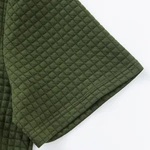 Nahaufnahme von dunkelgrünem Jacquard-Steppstoff an einem Herren-Poloshirt-Ärmel