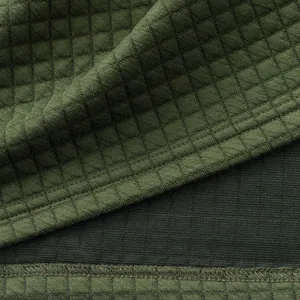 Makroaufnahme der olivgrünen Waffelstrick-Stoffstruktur eines schweren Herren-Poloshirts.