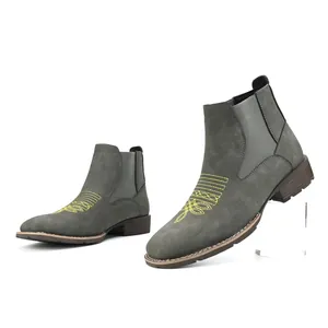 Detailweergave van grijze suède Chelsea boots met geel borduurwerk en elastische zijkanten