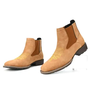 Close-up van bruine heren Chelsea boots met geel borduursel op de neus en elastiek