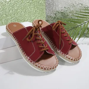 Gros plan sur des claquettes en toile rouge avec lacets et semelle espadrille