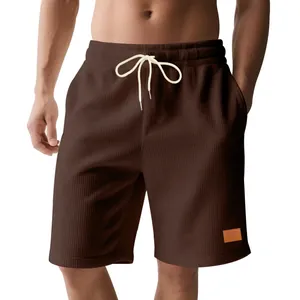 Dettaglio dei pantaloncini in velluto a coste marroni da uomo con coulisse.