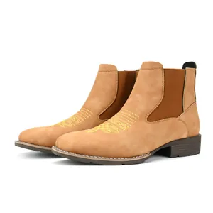 Detail van heren Chelsea boots met geel borduurwerk en elastische inzetstukken aan de zijkant