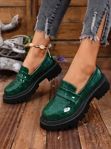 Mocassini platform da donna in vernice con stampa coccodrillo verde scuro ed elegante.