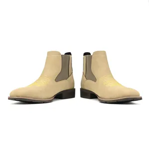 Gedetailleerd zijaanzicht van beige Chelsea-boots voor heren met geel borduursel.