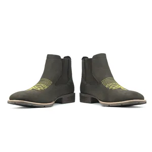 Gedetailleerd zijaanzicht van donkere Chelsea boots met gele borduring