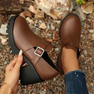 Κοντινό πλάνο από κομψά καφέ loafers με χοντρό τακούνι και τρακτερωτή σόλα από καουτσούκ.