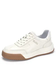 Vista laterale di una sneaker in pelle bianca con logo in rilievo e suola spessa.