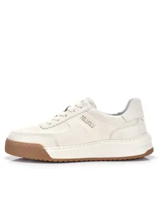 Vista laterale di sneakers in pelle bianca con zeppa, suola in gomma e logo del brand.