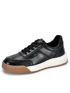 Dettaglio di sneaker in pelle nera da uomo con suole bianche spesse e punta in gomma