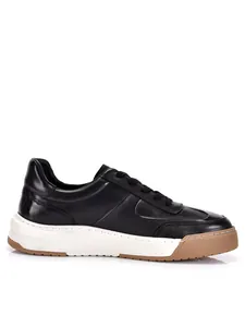 Profilo laterale di sneakers casual da uomo in pelle nera con spessa suola bianca