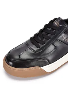 Dettaglio ravvicinato di sneaker casual da uomo in pelle nera con lacci