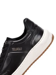 Dettaglio ravvicinato di sneaker casual da uomo in pelle nera con suola bianca