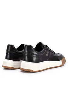 Vista laterale dettagliata di sneaker in pelle nera da uomo con spessa suola bianca