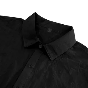 Close-up detail of a black linen shirt showing the textured fabric and collar