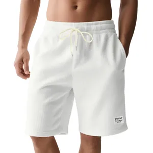 Close-up of white corduroy texture on men's drawstring shorts for a casual summer look.