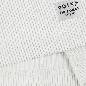 Detailed macro shot of white corduroy fabric texture and label on casual shorts