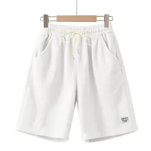 Detailed view of white corduroy men's shorts with drawstring and a decorative patch label.