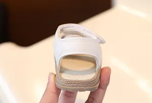 Detailansicht der Ferse einer weißen Baby-Sandale mit weicher Sohle und Klettverschluss.