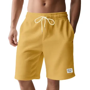 Detail shot of yellow corduroy drawstring shorts for men, casual summer style.