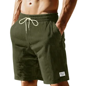 Macro view of olive green corduroy shorts showing drawstring and fabric texture.