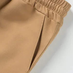 Close-up detail of khaki cargo shorts showing elastic waist and side pocket texture