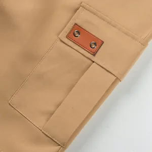 Close-up of the cargo pocket with a leather patch and eyelets on khaki shorts