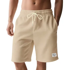 Macro view of beige corduroy men's shorts featuring white drawstring and stylish patch detail